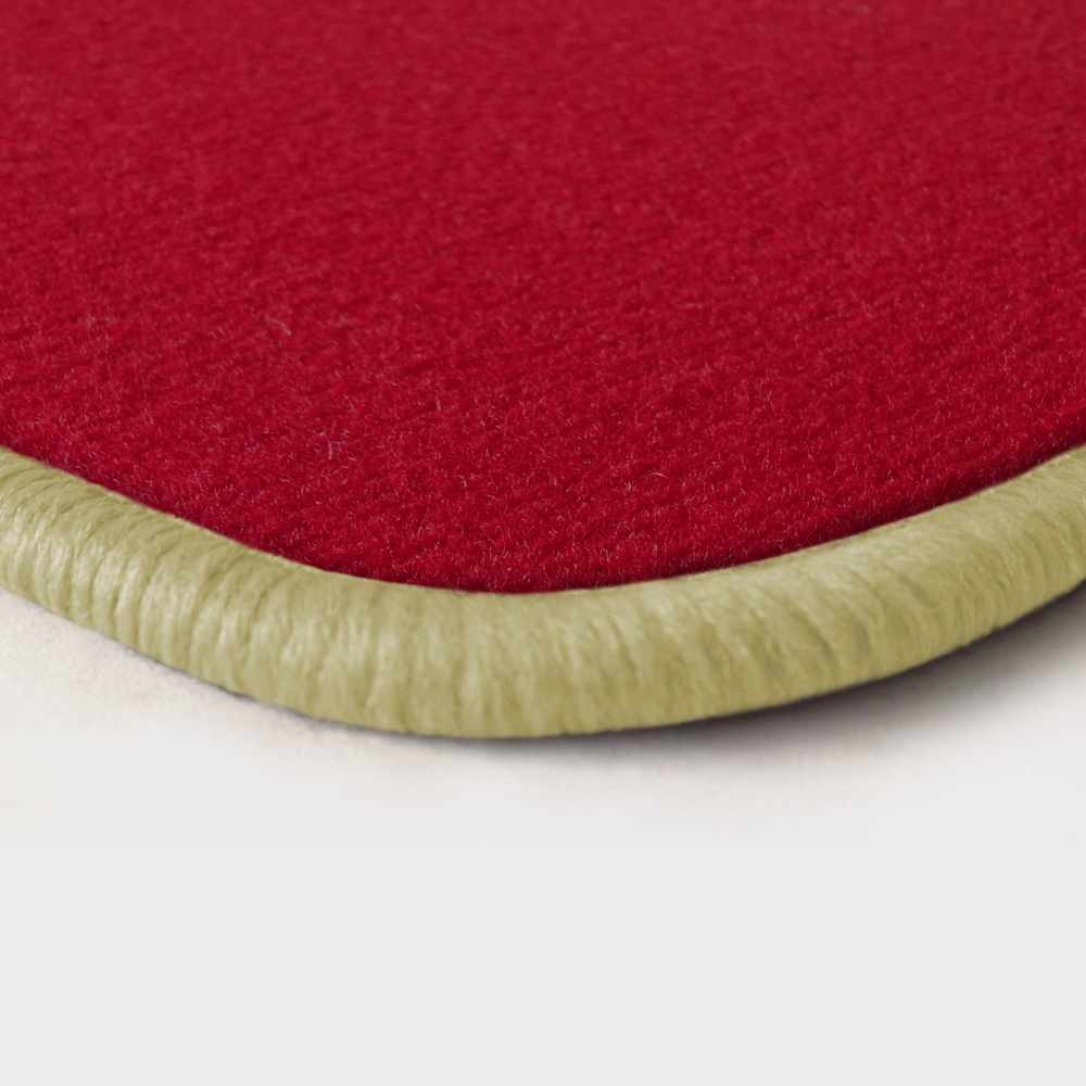 Eine Ecke als Beispiel einer Fussmatte Velours rot mit Rand in hellbeige.