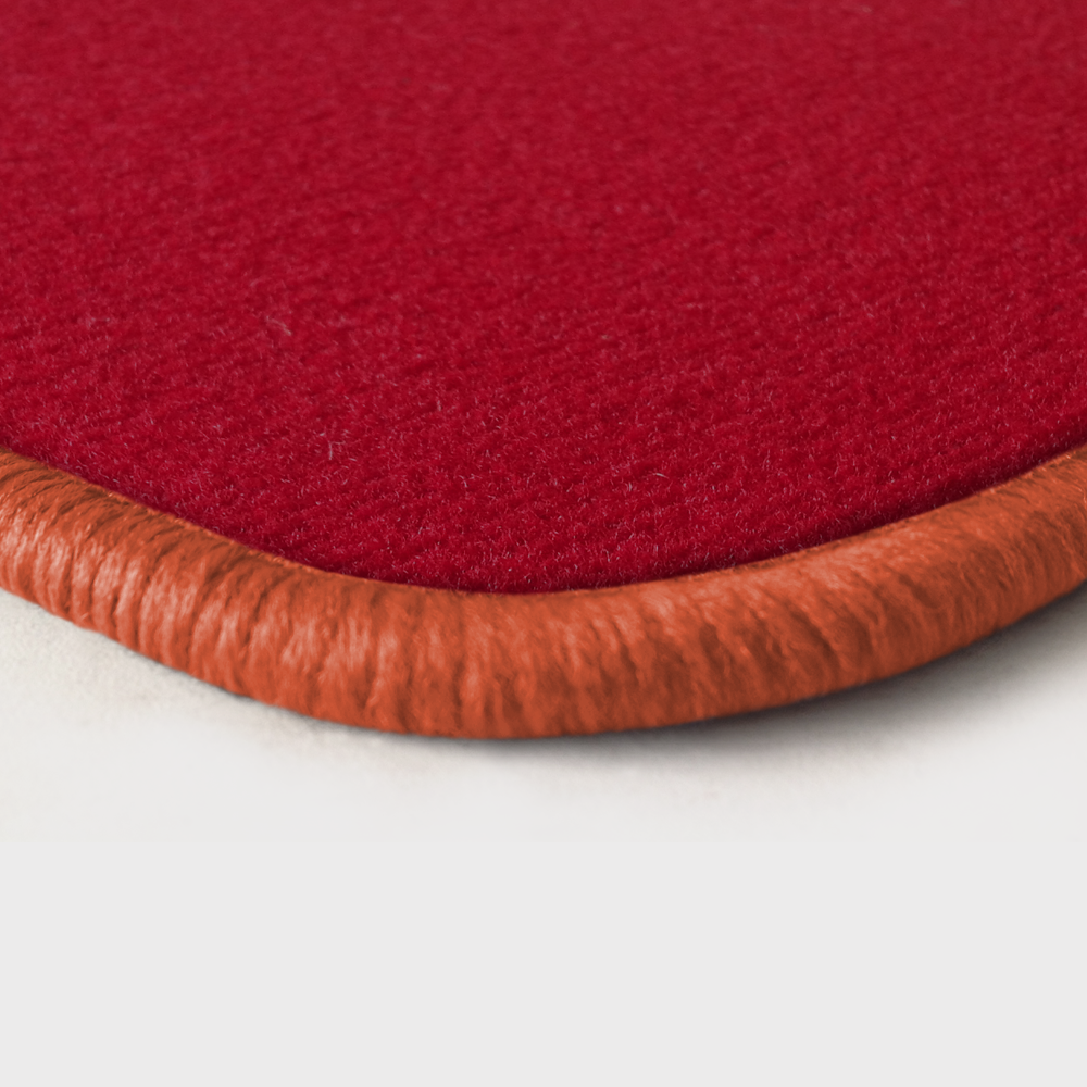 Eine Ecke als Beispiel einer Fussmatte Velours rot mit Rand in lachs.