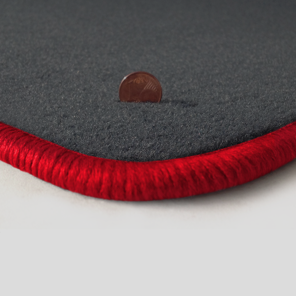 Eine Ecke als Beispiel einer Fussmatte Velours dunkelgrau mit Rand in rot.