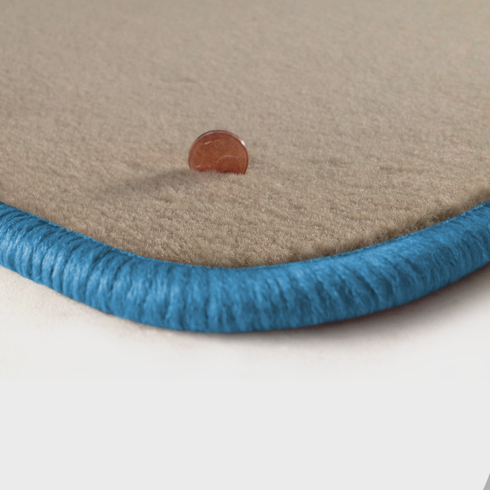 Eine Ecke als Beispiel einer Fussmatte Velours beige mit Rand in hellblau.