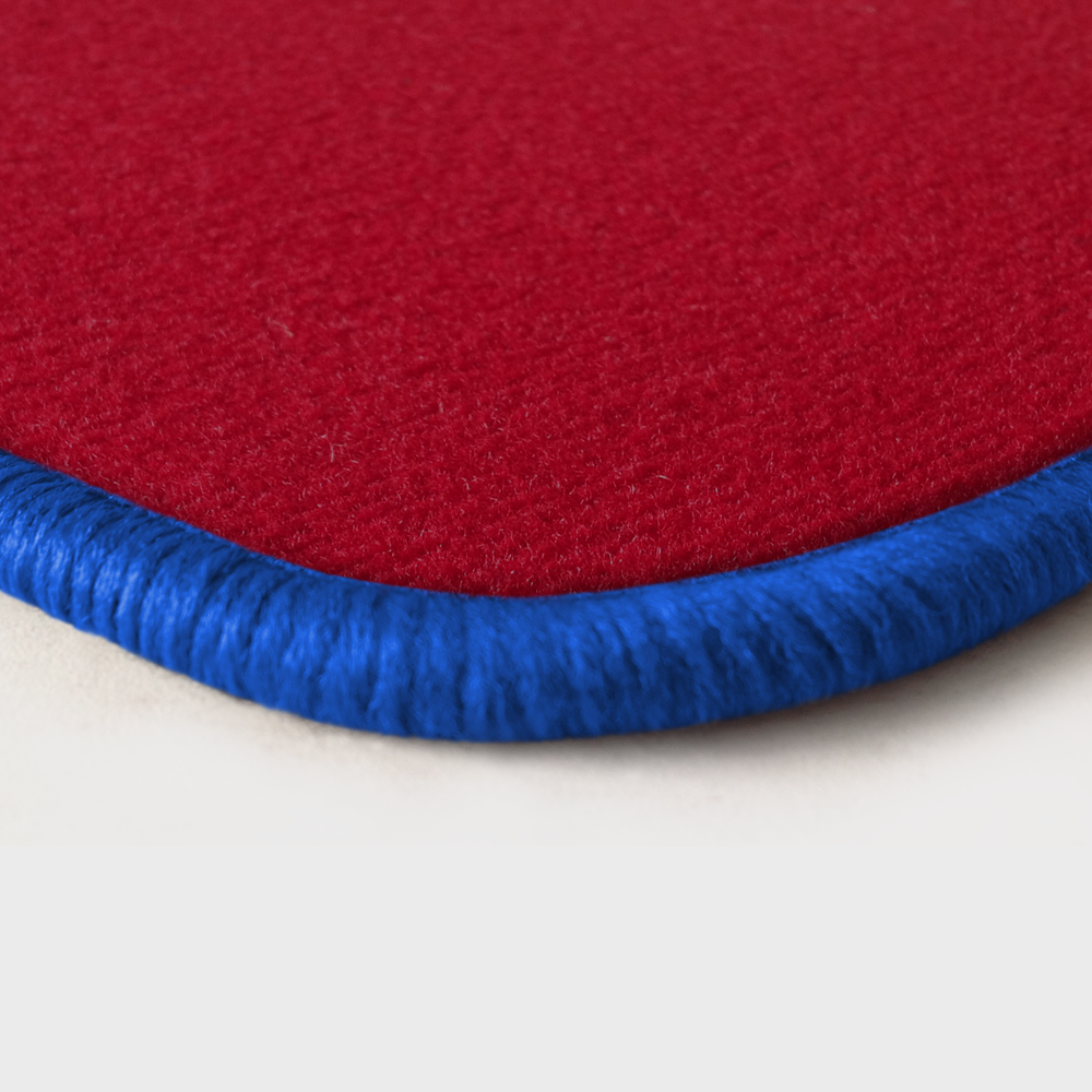 Eine Ecke als Beispiel einer Fussmatte Velours rot mit Rand in royalblau.