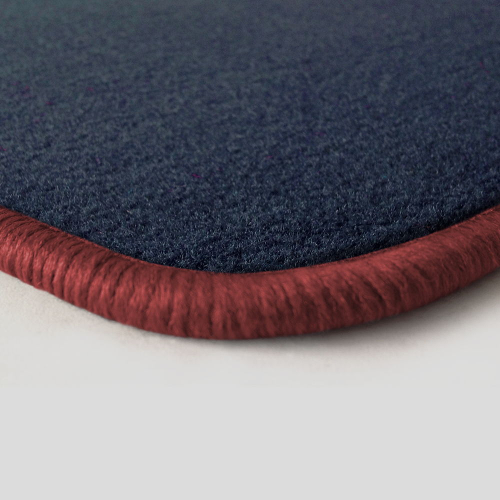 Eine Ecke als Beispiel einer Fussmatte Velours dunkelblau mit Rand in rose.