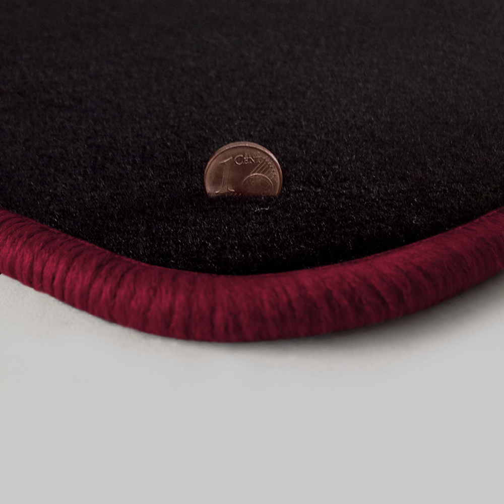 Eine Ecke als Beispiel einer Fussmatte Velours schwarz mit Rand in bordeaux.