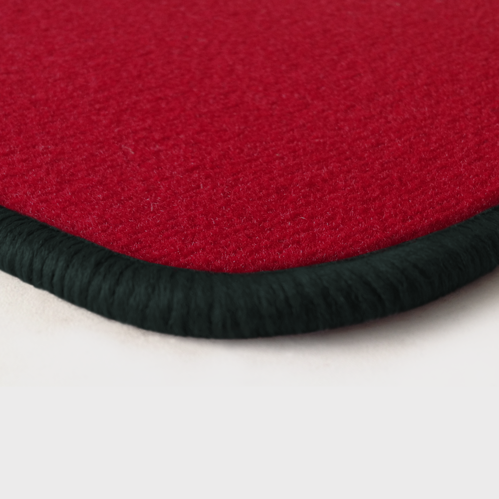 Eine Ecke als Beispiel einer Fussmatte Velours rot mit Rand in anthrazit.