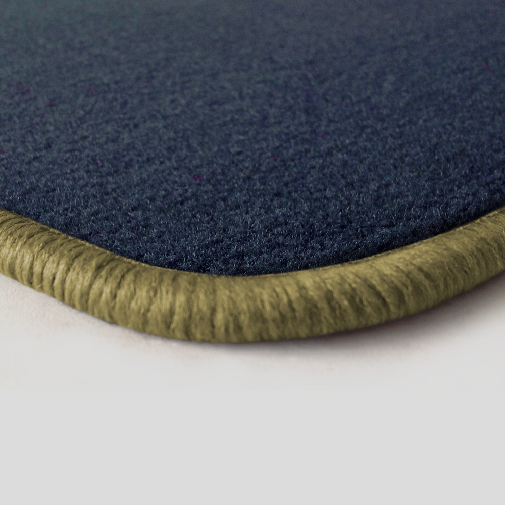 Eine Ecke als Beispiel einer Fussmatte Velours dunkelblau mit Rand in beige.