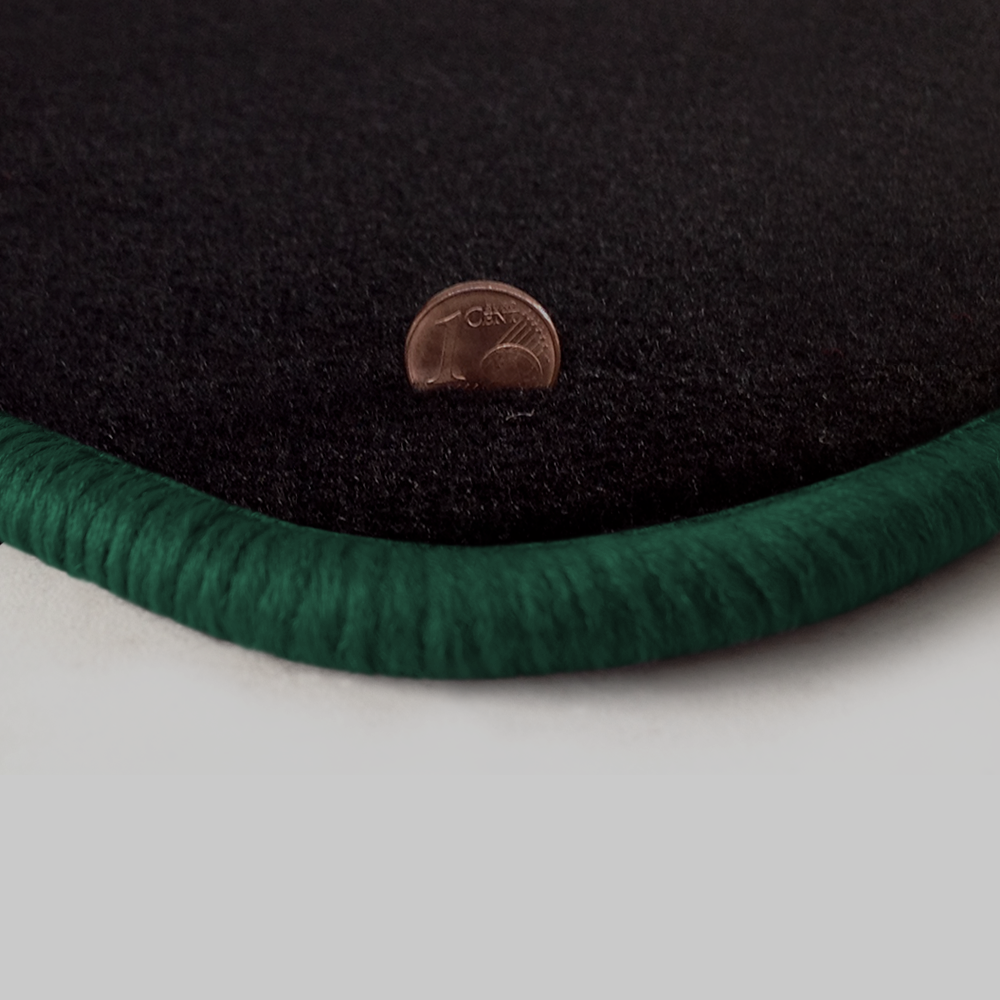 Eine Ecke als Beispiel einer Fussmatte Velours schwarz mit Rand in dunkelgruen.